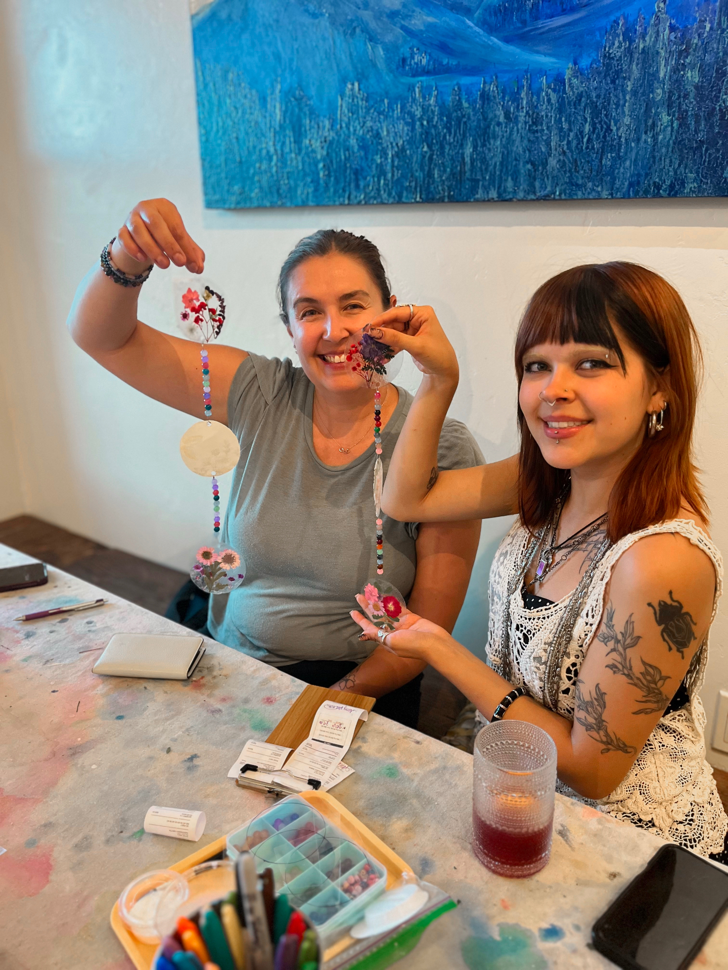 Guests holding pressed-flower suncatchers they made at Rabbitbrush Studio